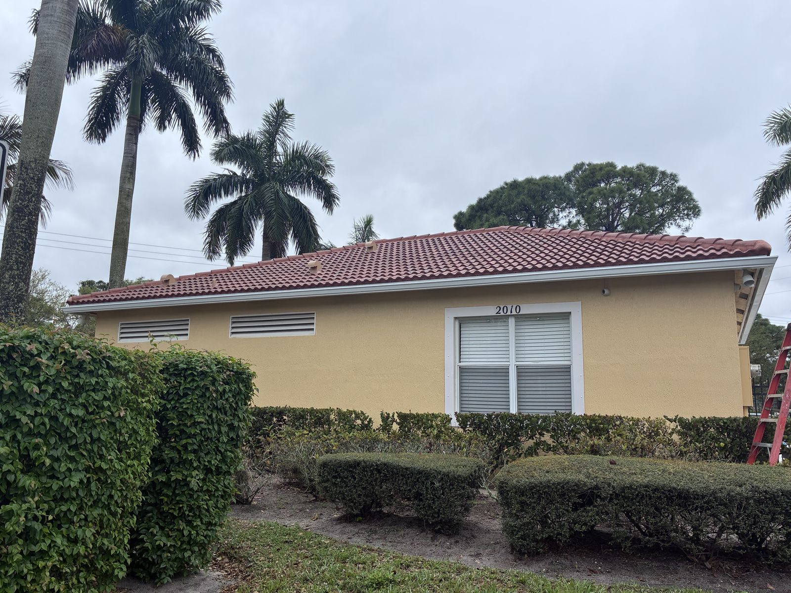 White seamless gutters along the eave of a tile-roof home