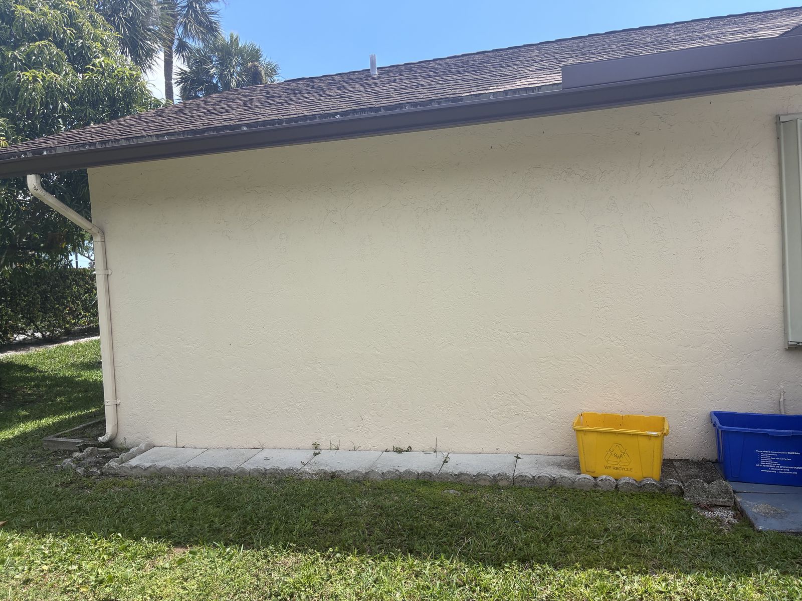 Seamless gutter and downspout carrying water to grade