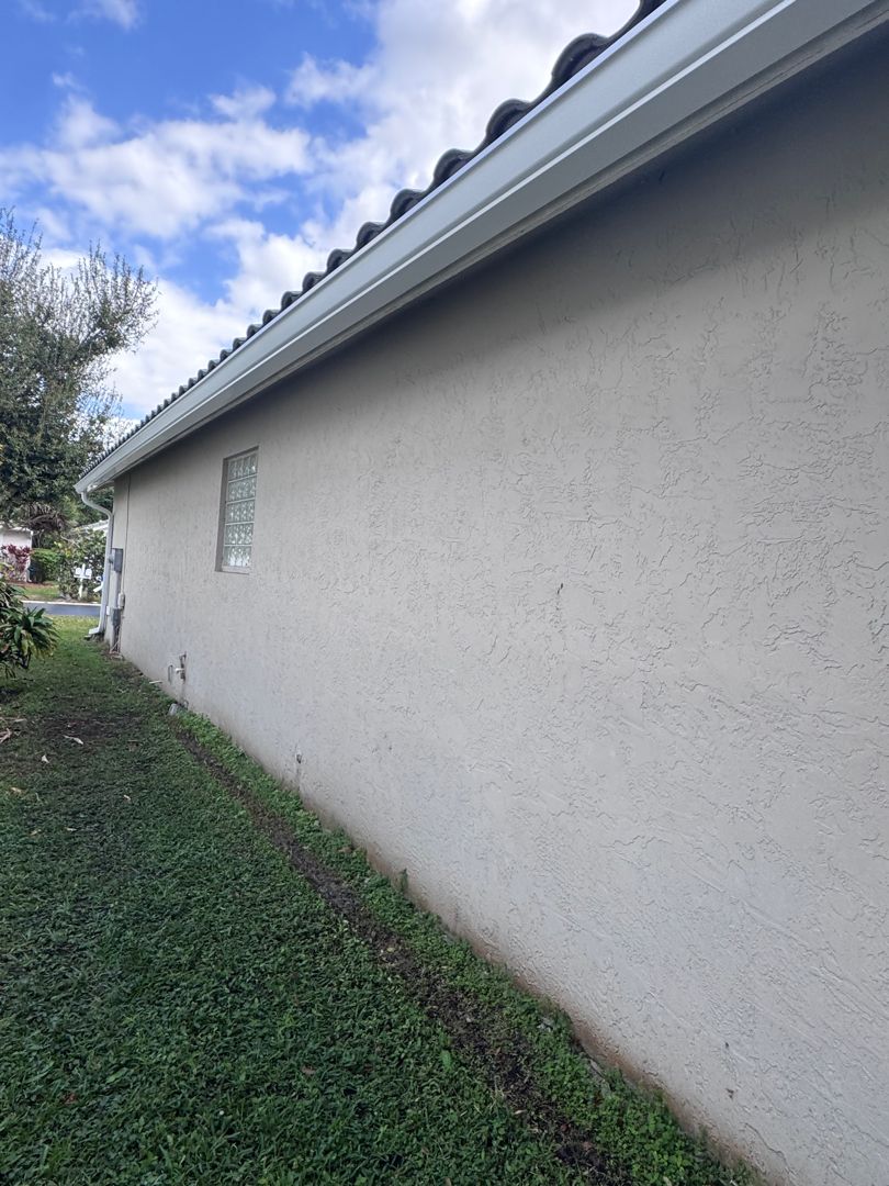 Seamless gutter along the side of a stucco home