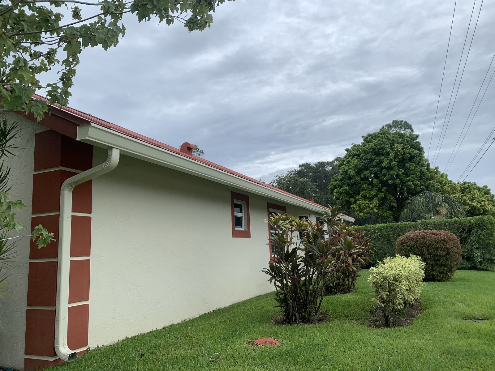 Seamless gutter and downspout on a metal-roof home