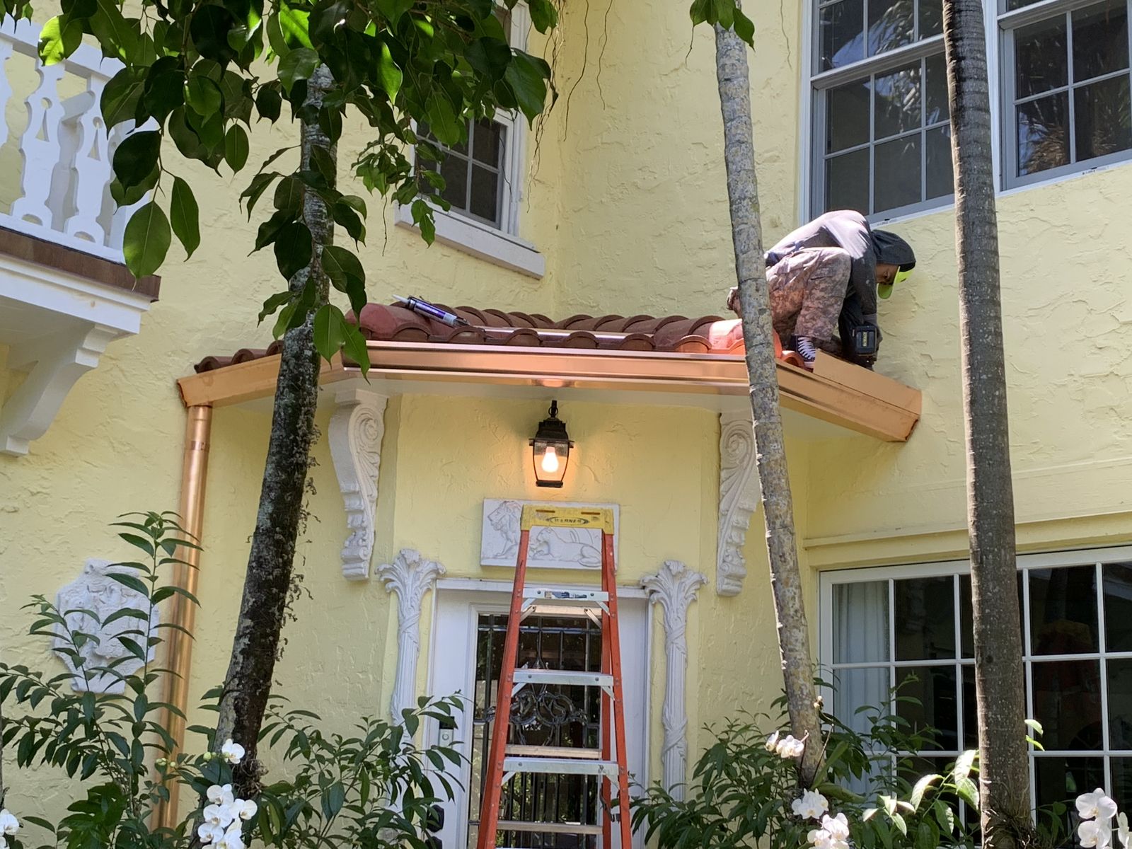 Copper half-round seamless gutter installation in progress on a South Florida home