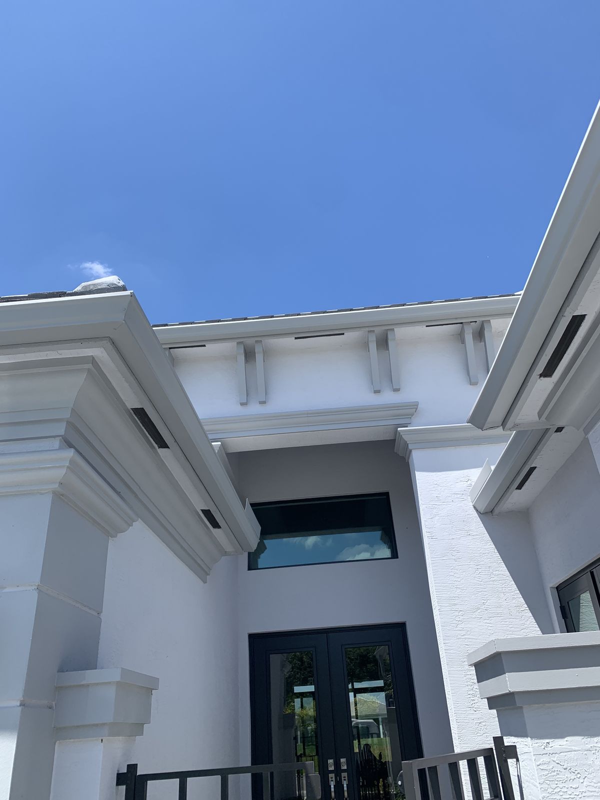 White seamless gutters with decorative brackets on a modern South Florida home