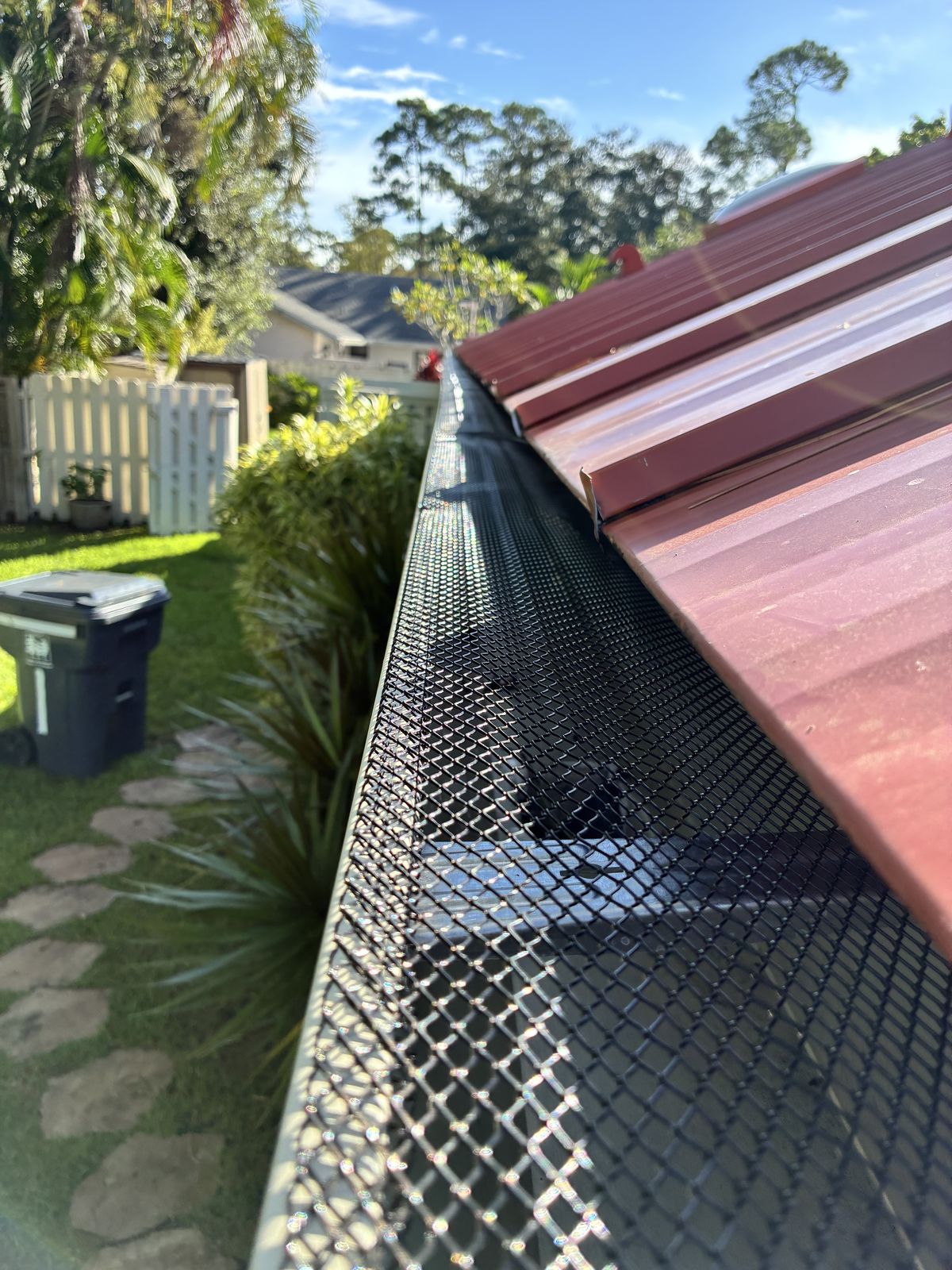 Black leaf guard / gutter screen on a metal-roof home